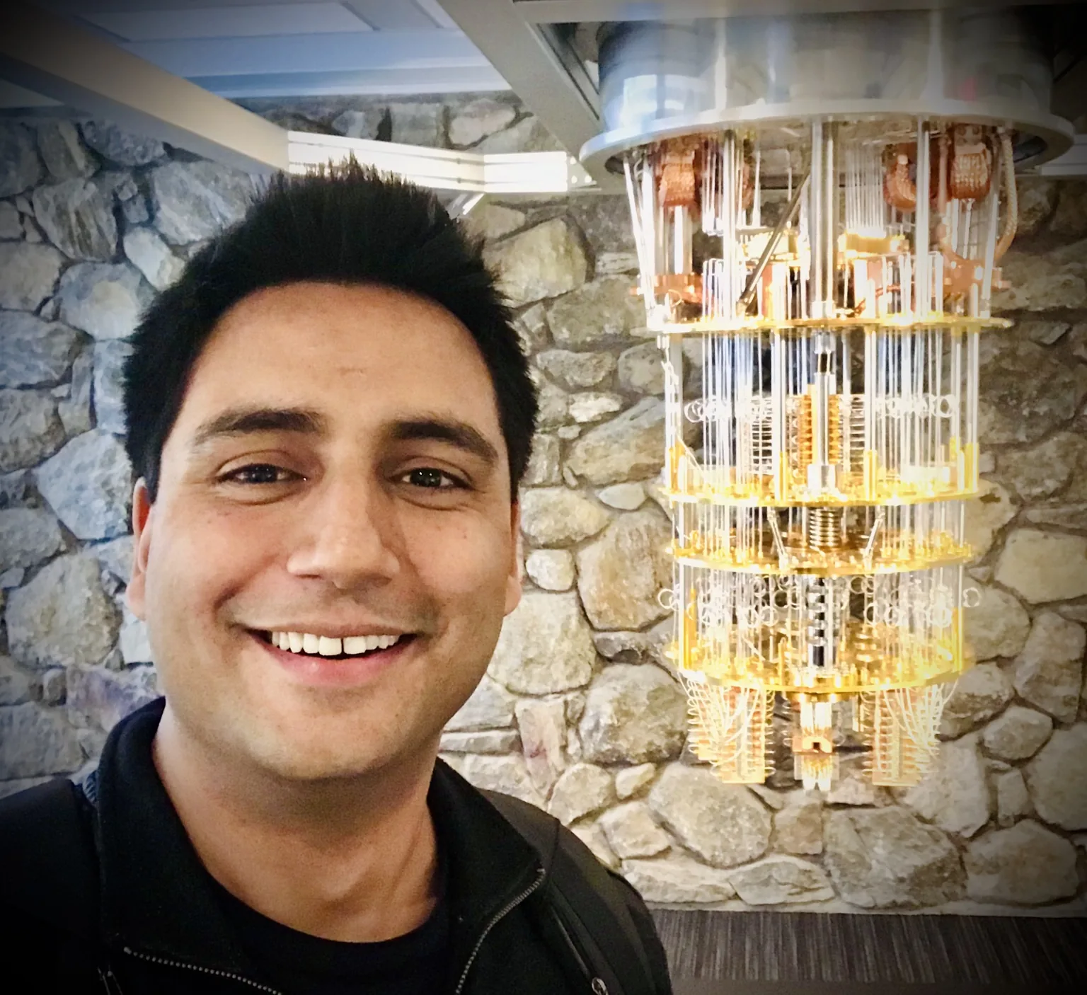Sushain Pandit beside a quantum computing system